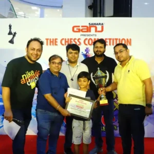 7years old student with parents receiving winning trophy from the organiser chess tournament lucknow