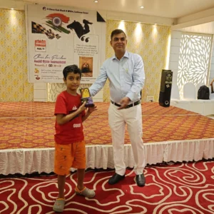 9years old student receiving winning trophy from the organiser chess tournament lucknow