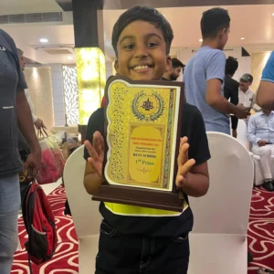 student holding winning token with both hand with smile after 2nd position on chess tournament